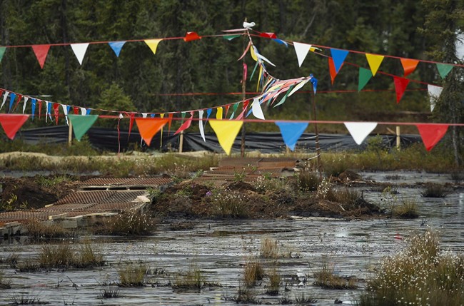 Flags hung over a pipeline leak to keep birds away as crews work to contain and clean up a pipeline spill at Nexen Energy's Long Lake facility, near Fort McMurray, Alta., on July 22, 2015. 