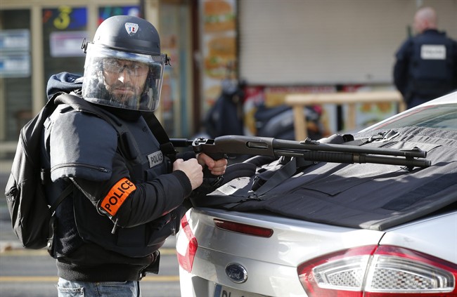 A police officer takes position after a fatal shooting which took place at a police station in Paris, Thursday, Jan. 7, 2016. Officers shot and killed a knife-wielding man with wires protruding from his clothes at a police station in northern Paris on Thursday, French officials said, a year to the day after an attack on the French satirical newspaper Charlie Hebdo launched a bloody year in the French capital. (AP Photo/Michel Euler)