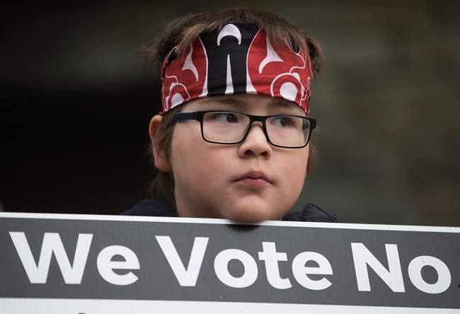 FILE PHOTO: Jamie Antone, 9, of the Squamish First Nation, holds a sign as protesters gather outside National Energy Board hearings on the proposed Trans Mountain pipeline expansion in Burnaby, B.C., on January 19, 2016.