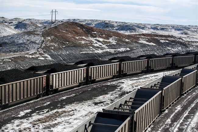 FILE - In this Jan. 9, 2014, file photo, rail cars are filled with coal and sprayed with a topper agent to suppress dust at Cloud Peak Energy's Antelope Mine north of Douglas, Wyo.