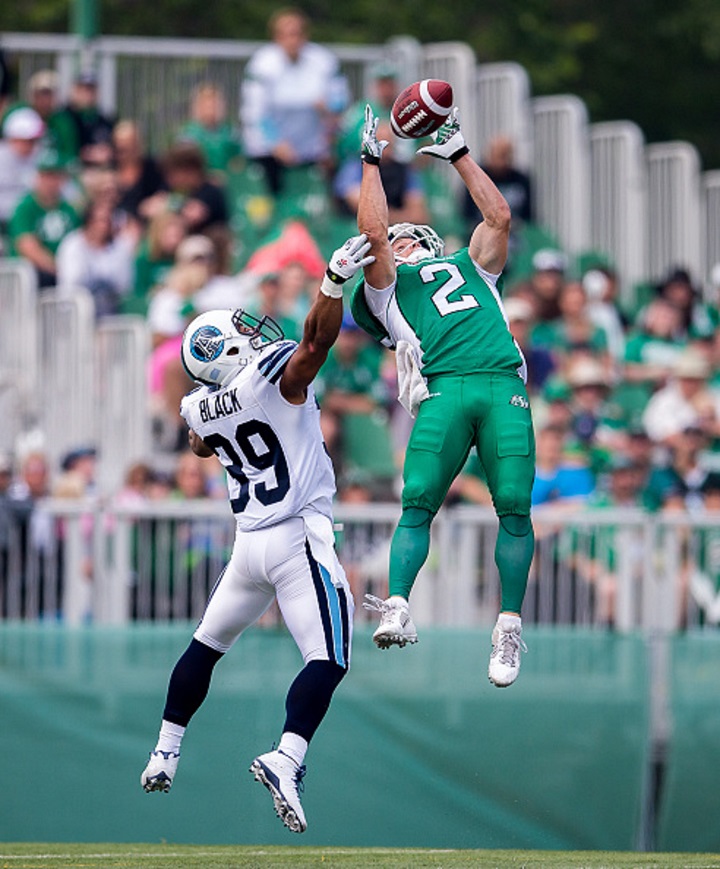 Ryan Smith of the Saskatchewan Roughriders goes up to make a spectacular catch in front of Toronto Argonauts Matt Black during a game in Regina, Saskatchewan on July 5, 2015.