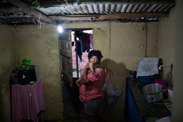 In this Jan. 30, 2016 photo, Solange Ferreira carries her son Jose Wesley at their house in Bonito, Pernambuco state, Brazil.