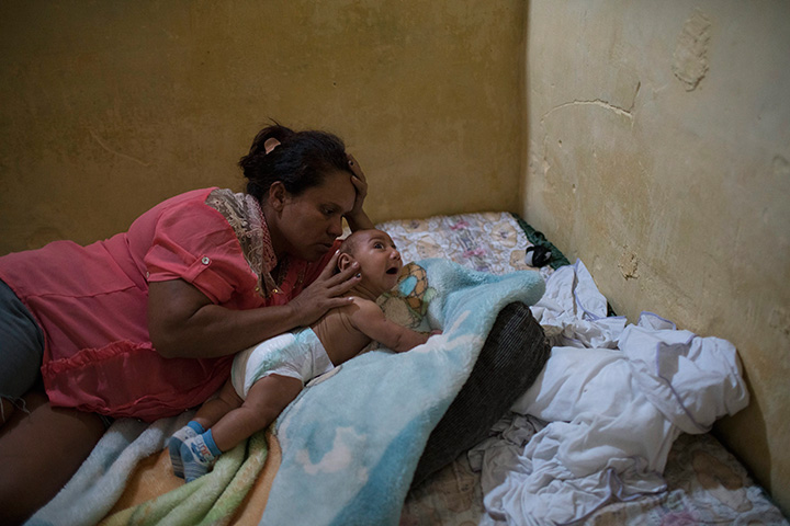 In this Jan. 30, 2016 photo, Solange Ferreira tries to make her son Jose Wesley sleep, in Bonito, Pernambuco state, Brazil.