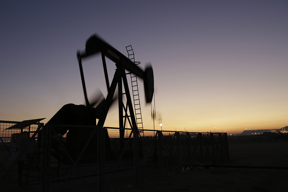 An oil pump works at sunset Monday, Jan. 18, 2016, in the desert oil fields of Sakhir, Bahrain. Iran is aiming to increase its oil production by 500,000 barrels per day now that sanctions have been lifted under a landmark nuclear deal with world powers, a top official said.