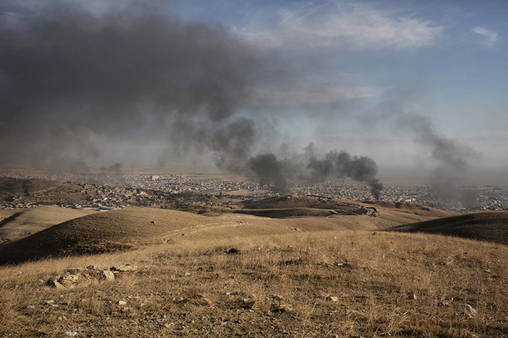 In this Nov. 12, 2015 file photo, smoke rises over Sinjar, northern Iraq from oil fires set by Islamic State militants as Kurdish Iraqi fighters, backed by U.S.-led airstrikes, launch a major assault. 