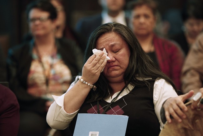 A woman wipes away a tear around a sharing circle at the 2nd National Roundtable on Missing and Murdered Indigenous Women and Girls in Winnipeg on Thursday, Feb. 25, 2016.