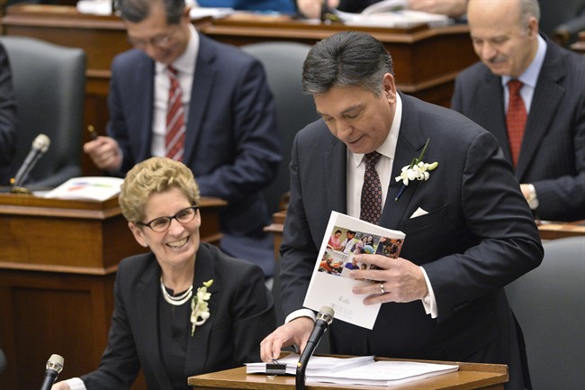 Ontario Finance Minister Charles Sousa, right, delivers the Ontario 2016 budget next to Premier Kathleen Wynne, left, at Queen's Park in Toronto on Thursday, February 25, 2016. 