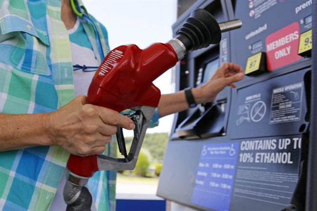 FILE - In this Thursday, July 16, 2015, file photo, a customer re-fuels her car at a Costco in Robinson Township, Pa. 
