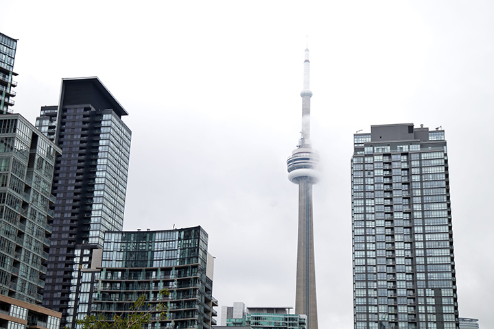 The CN Tower is barely visible amidst the looming grey clouds in these photos taken on June 30, 2015 in Toronto\’s downtown core.
