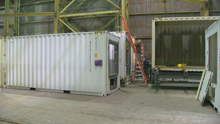 Workers at Calgary-based Ladacor Advanced Modular Systems work on an old shipping container that will be turned into one of 63 suites in a new hotel.