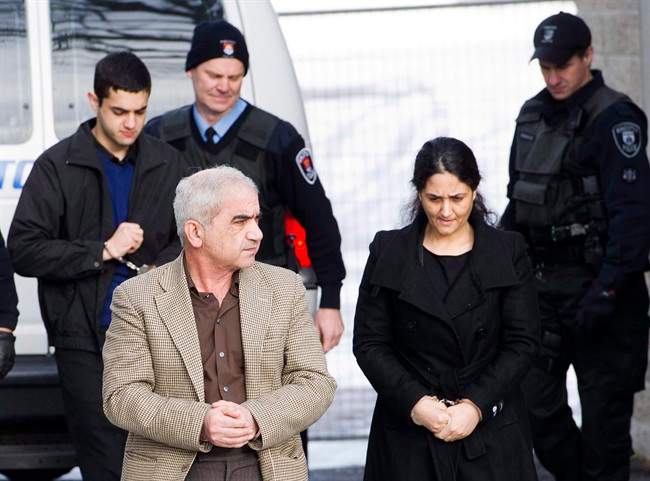 Mohammad Shafia, front left, Tooba Yahya, front right, and their son Hamed Shafia, back left, are escorted at the Frontenac County courthouse in Kingston, Ont., on January 28, 2012.