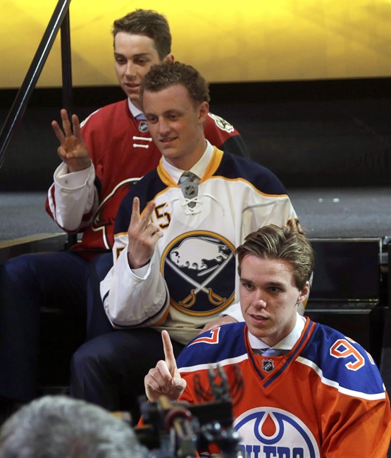 Connor McDavid, foreground, first overall pick; Jack Eichel, center, second overall pick; and Dylan Strome, third overall pick; pose for cameras during the first round of the NHL hockey draft, Friday, June 26, 2015, in Sunrise, Fla. Linked together even before they were selected with the first two picks of the NHL Draft last June, McDavid and Eichel continue to travel a similar path.