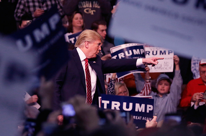Republican presidential candidate Donald Trump points out a protester during a rally at Macomb Community College, Friday, March 4, 2016, in Warren, Mich. 