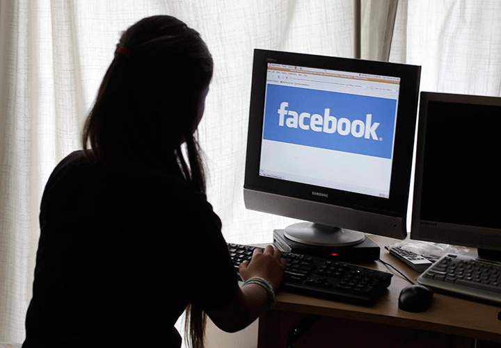 In this Monday, June 4, 2012, file photo, a girl looks at Facebook on her computer in Palo Alto, Calif. 