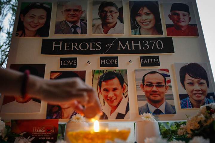 A Malaysian woman lights a candle during a special prayer for the ill-fated Malaysia Airlines Flight 370 at a church in Kuala Lumpur, Malaysia on Tuesday, March 8, 2016.