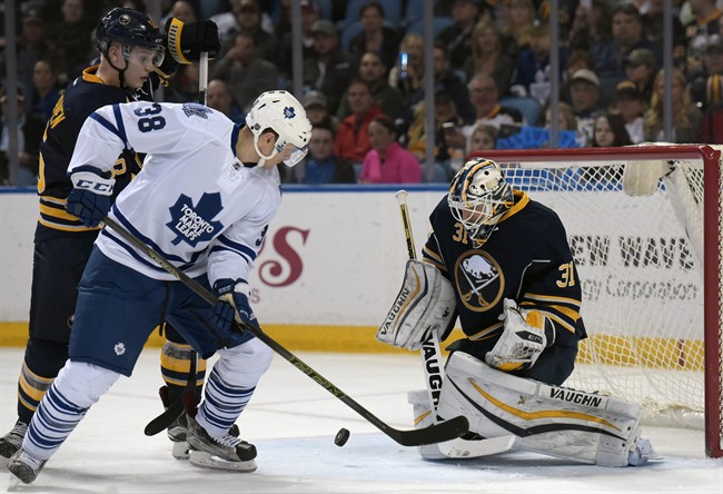 Toronto Maple Leafs center Colin Greening (38) deflects the puck as Buffalo Sabres goaltender Chad Johnson (31) and defenseman Rasmus Ristolainen, left, defend during the second period of an NHL hockey game, Thursday, March 31, 2016, in Buffalo, N.Y.