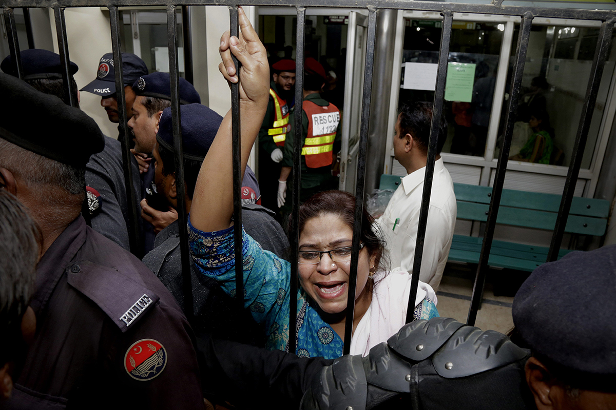 A woman weeps for her injured family members as she tries to speak to security at a local hospital in Lahore, Pakistan, Sunday, March, 27, 2016.