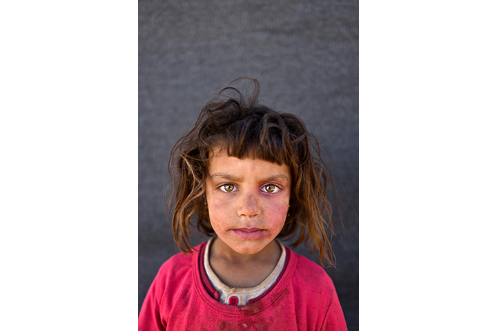 In this Friday, March 11, 2016 photo, Syrian refugee girl Mona Emad, 5, from Hassakeh, Syria, poses for a picture at an informal tented settlement near the Syrian border on the outskirts of Mafraq, Jordan.