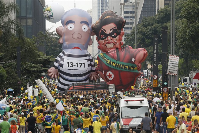 Demonstrators parade large inflatable dolls depicting Brazil's former President Luiz Inacio Lula da Silva in prison garb and current President Dilma Rousseff dressed as a thief.