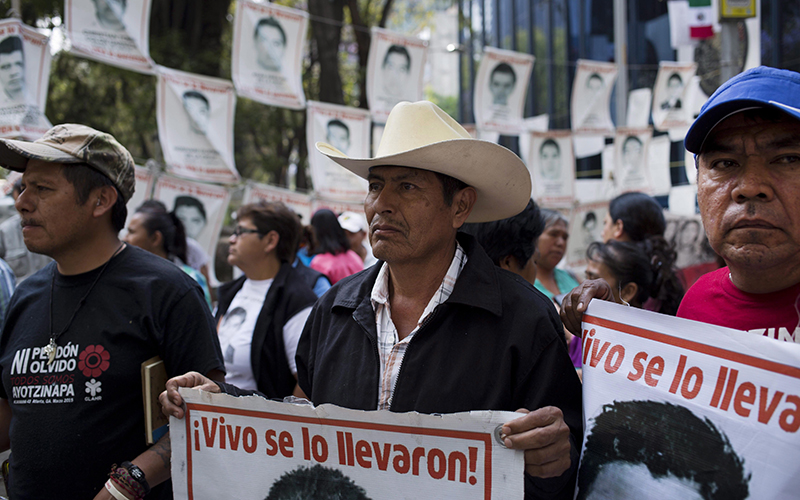 Relatives of 43 missing students from the Isidro Burgos rural teachers' college hold pictures of their missing loved ones after meeting with  Attorney General Arely Gomez Gonzalez in Mexico City, Thursday, March 17, 2016. 