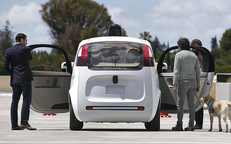 Riders enter the Google's new self-driving prototype car for a ride during a demonstration at Google campus on Wednesday, May 13, 2015, in Mountain View, Calif. 