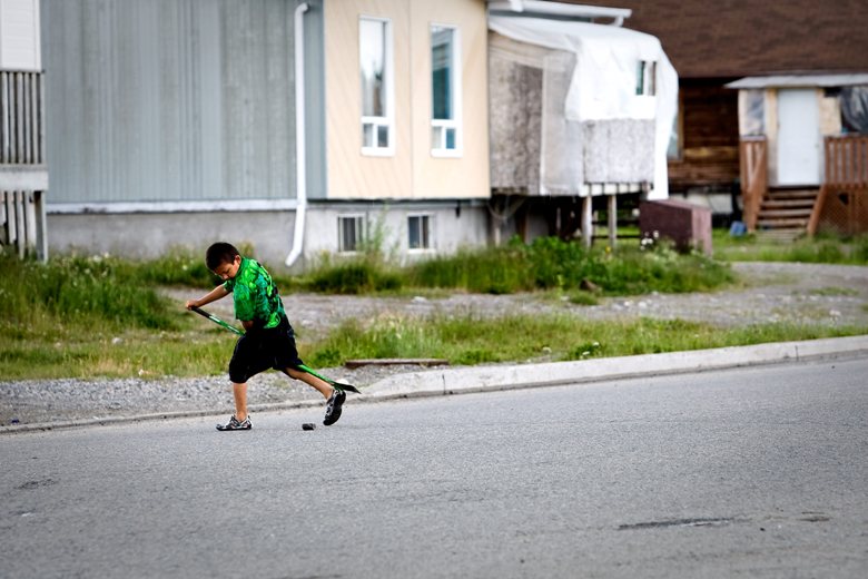 A young First Nations child plays street hockey, July 17, 2009.