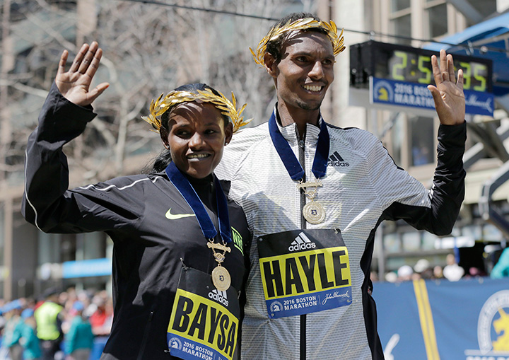 Atsede Baysa, left, and Lemi Berhanu Hayle, both of Ethiopia, pose for photos after they won the women’s and men’s divisions of the 120th Boston Marathon on Monday, April 18, 2016, in Boston.