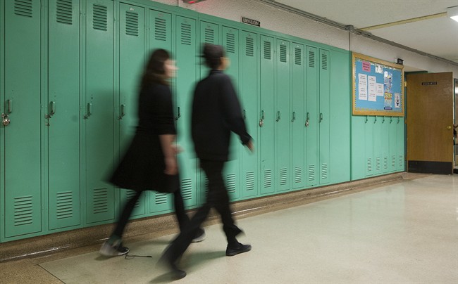 Students walk by lockers in a Montreal school.