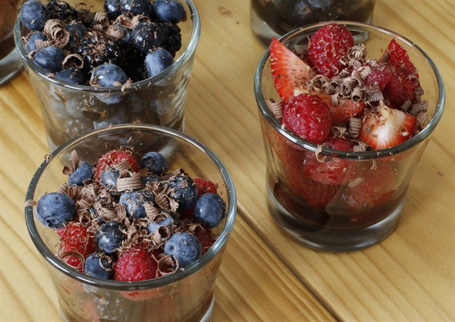 Fresh berries served with a sugar syrup spiked with cocktail bitters and garnished with shavings of dark chocolate .