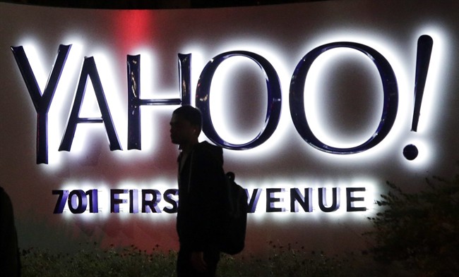 In this Nov. 5, 2014, file photo a person walks in front of a Yahoo sign at the company's headquarters in Sunnyvale, Calif.