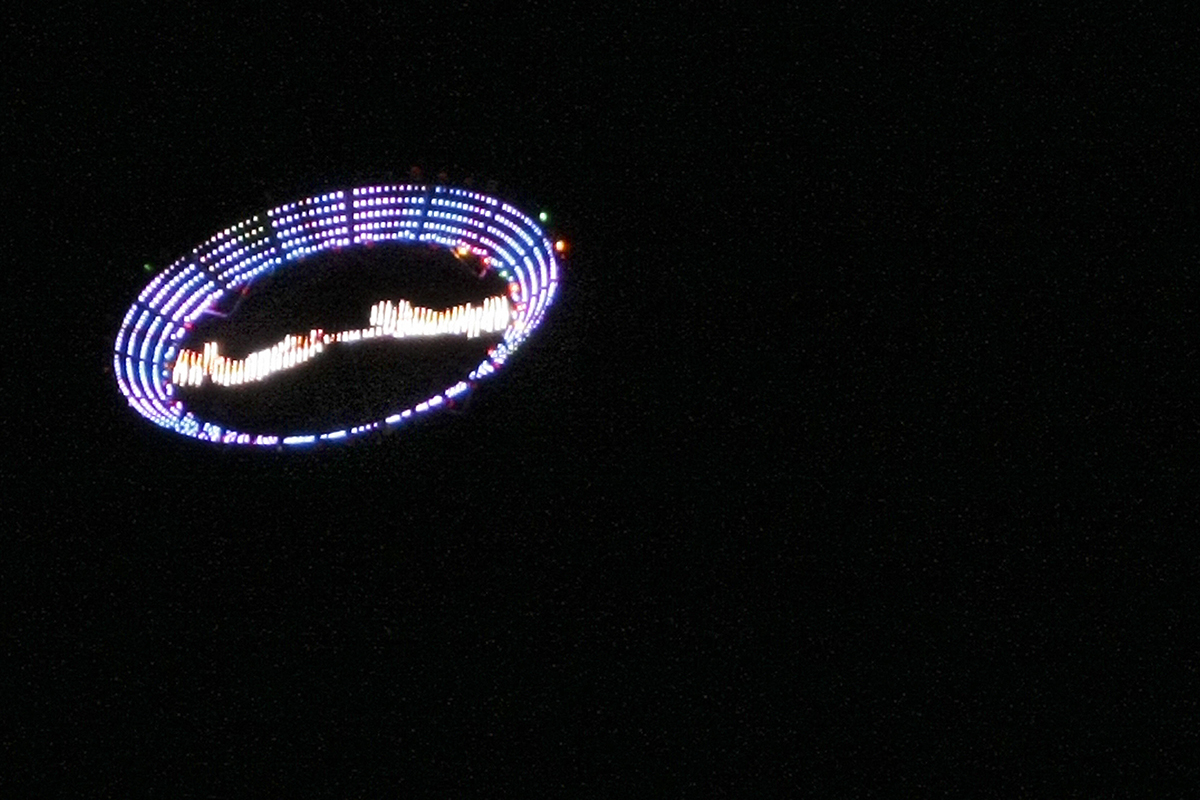 US plastic artist Peter Coffin's "Flying Saucer" --a 7-meter, LED-studded, SMS-controlled flying saucer and lifted by a helicopter-- overflies Ipanema beach, on May 23, 2009, in Rio de Janeiro, Brazil. 
