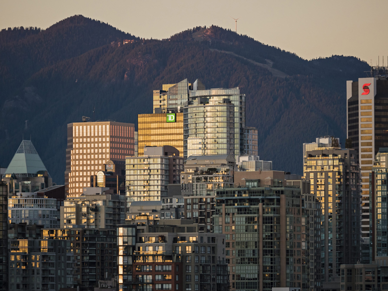 Sunset colours reflect off the glass of Vancouver’s crowded downtown skyline,