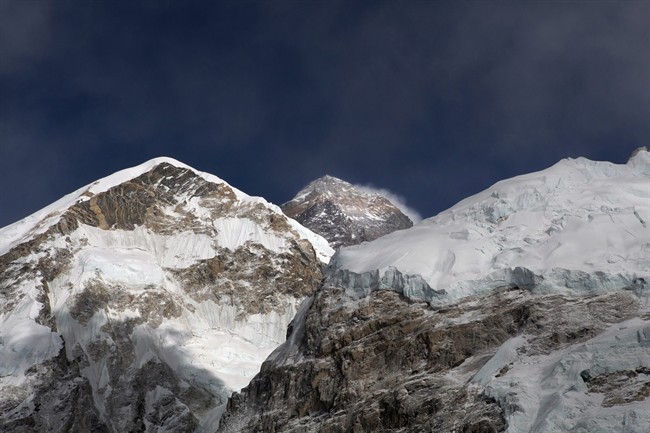 FILE - In this March 7, 2016 file photo, Mount Everest, in middle, altitude 8,848 meters (29,028 feet), is seen on the way to base camp. High winds have delayed dozens of climbers trying to reach the summit of Mount Everest, a mountaineer official said Wednesday, May 18, 2016. (AP Photo/Tashi Sherpa, File).
