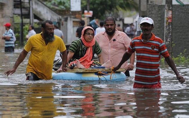 An elderly Sri Lankan woman is shifted on a makeshift raft at a flooded area in Colombo, Sri Lanka, Tuesday, May 17, 2016. 