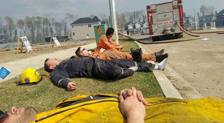 Firefighters take a rest from battling a wildfire in Fort McMurray. Uploaded to Facebook by a firefighter and EMT with the Regional Municipality of Wood Buffalo on May 6, 2016. Date and exact location of photo is unknown. (CREDIT: Facebook/ Troy Palmer)