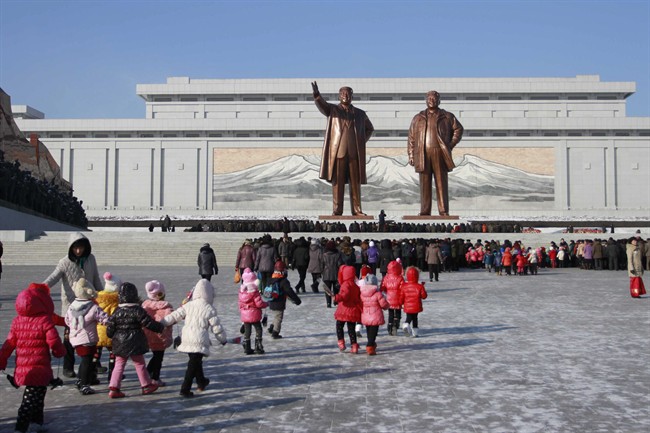 In this Dec. 16, 2014 file photo, North Koreans gather at the Mansu Hill where the statues of the late leaders Kim Il Sung, and Kim Jong Il tower over them, in Pyongyang, North Korea.