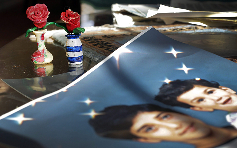 Prison artwork created by Adnan Syed sits near family photos in the home of his mother, Shamim Syed, in Baltimore. 