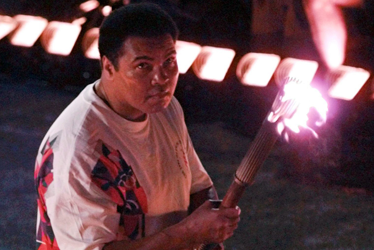 In this Friday, July 19, 1996 file photo, Muhammad Ali holds a torch as he watches as the flame climb up to the Olympic cauldron during the opening ceremonies of the Summer Olympics in Atlanta.