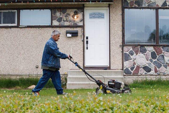 Roy Hann mows his lawn after returning to the city as residents re-enter fire-ravaged Fort McMurray, Alta., on Wednesday, June 1, 2016.