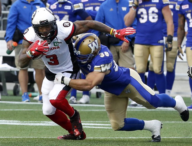 Ottawa Redblacks' Travon Van is tackled by Winnipeg Blue Bombers' Ian Wild during a pre-season game in Ottawa on June 13, 2016.