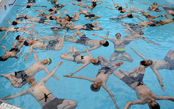 People take part in a yoga session in a swimming pool on International Yoga Day in Jodhpur, India on June 21, 2016.