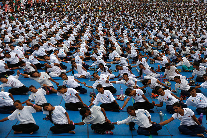People holds hands as they attempt to create a record for the longest human yoga chain with more than 8000 participants at an event to celebrate International Yoga Day in Ahmadabad, India, Tuesday, June 21, 2016.