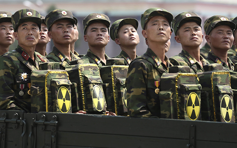 North Korean soldiers turn and look towards leader Kim Jong Un as they carry packs marked with the nuclear symbol as they parade during a ceremony marking the 60th anniversary of the Korean War armistice in Pyongyang, North Korea On July 27, 2016.