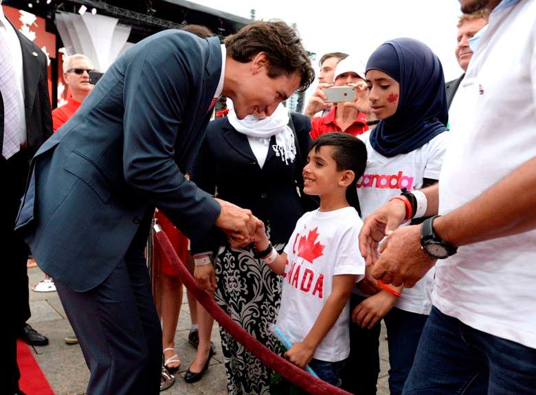 FILE - Prime Minister Justin Trudeau greets members of a Syrian refugee family during Canada Day celebrations on Parliament Hill, in Ottawa on Friday, July 1, 2016.