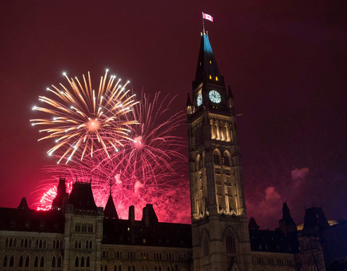 Fireworks light up the sky red behind the Peace Tower during Canada Day celebrations on Parliament Hill on Friday, July 1, 2016 in Ottawa. 