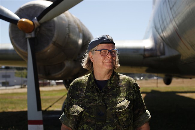 Master Cpl. Natalie Murray, who works at the instrument flight rules control centre at CFB Comox, poses for a photograph beside the Canadair CL-28 Argus Mark 1 at Heritage Air Park near the base in Comox, B.C., Friday, July 29, 2016. 