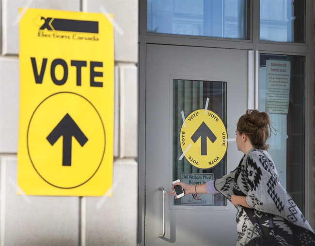 A woman enters Maple High School in Vaughan, Ont., to cast her vote in the Canadian federal election on Monday, Oct. 19, 2015. Elections Canada officials admit they were overwhelmed by the length of last year's federal election campaign.