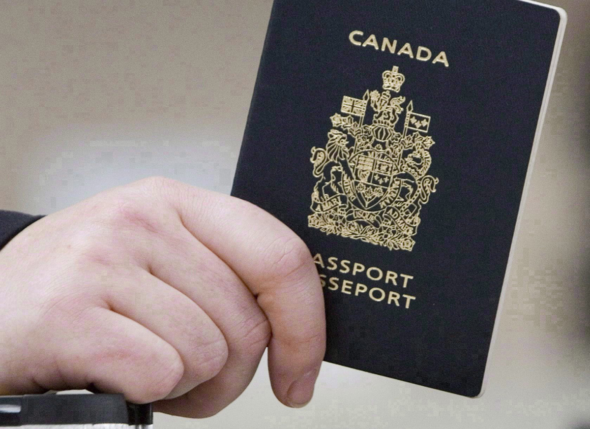 A passenger holds a Canadian passport before boarding a flight in Ottawa on Jan 23, 2007. Federal officials used photo-matching technology to identify 15 high-risk people - all wanted on immigration warrants - who used false identities to apply for travel documents. 