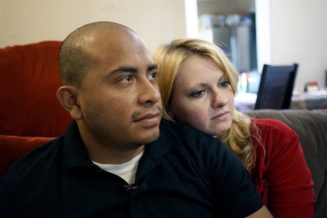 Dallas Police Department Officer Jorge Barrientos, left, is pictured recovering at his home with his girlfriend, Bethany Knutson, Sunday, July 10, 2016, in Dallas. Barrientos was shot in the hand and struck by shrapnel when a gunman attacked officers at a protest against police brutality July 7, 2016.