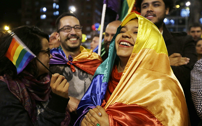 People celebrate in a park as they listen to the announcement from Havana, Cuba, that delegates of Colombia's government and leaders of the Revolutionary Armed Forces of Colombia reached a peace accord to end their half-century civil war, in Bogota, Colombia.